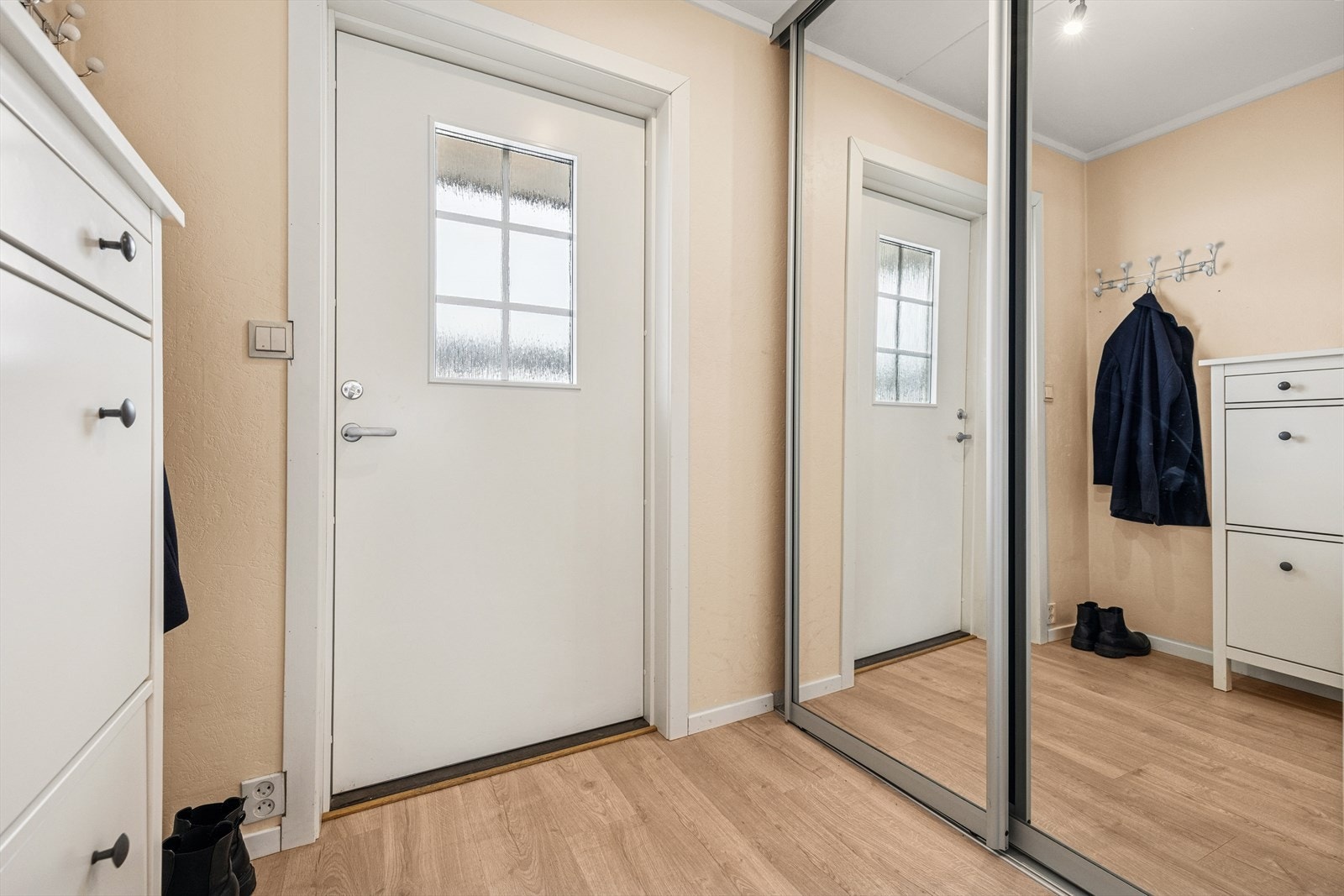 Gang med praktisk syvedørsgarderobe med speilfronter. Her er det god plass til å henge fra seg yttertøy og plassere sko. Galleribilde