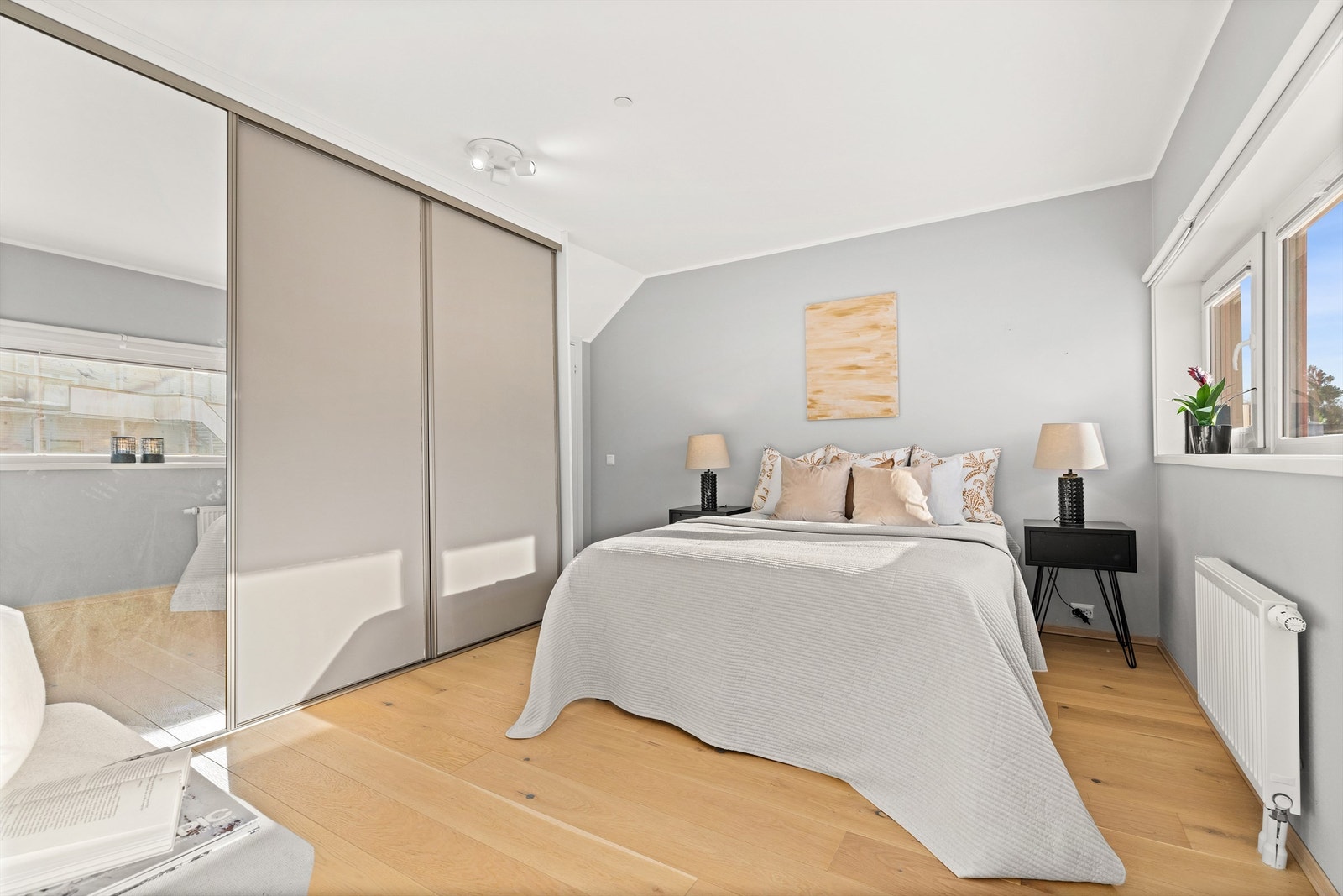 Romslig soverom med en stor skyvedørsgarderobe for effektiv oppbevaring. Galleribilde