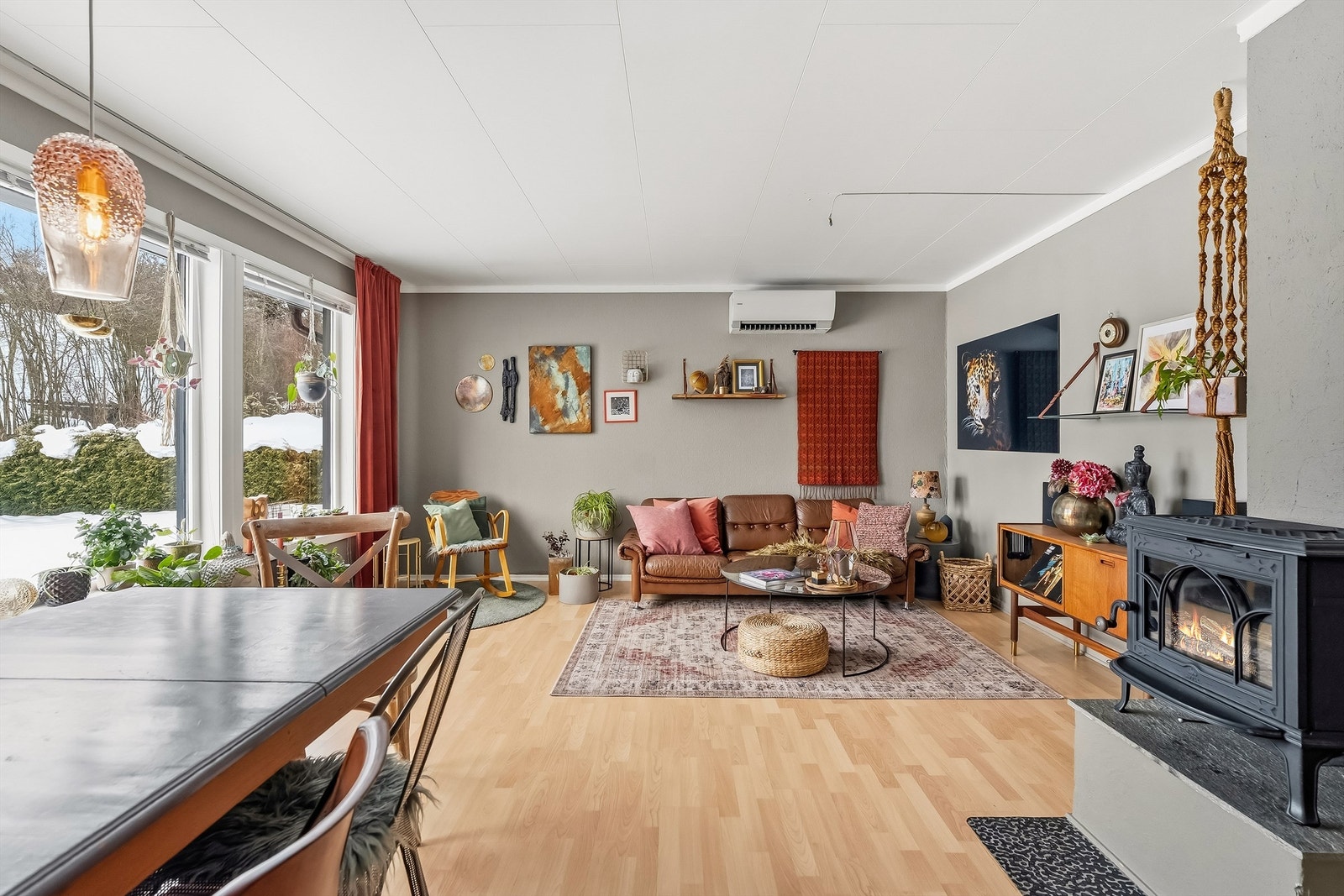 Det er god plass til sittegruppe og spisebord, og stuen har både hyggelig område med peisovn, og det er varmepumpe plassert over sittegruppe. Galleribilde