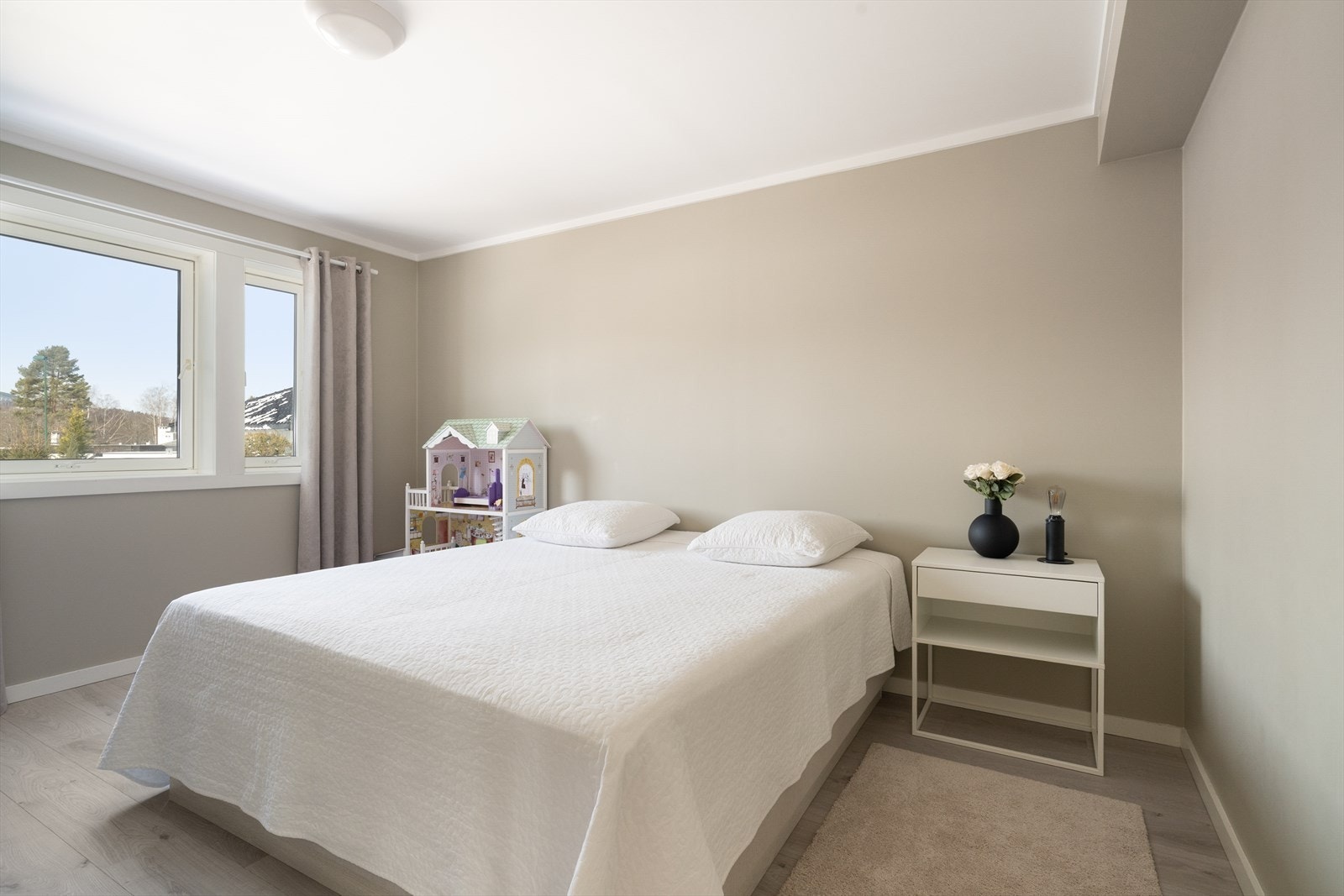 Soverommet har pene overflater i behagelige fargetoner og god plass til ønsket soveromsmøblement. I gangen utenfor er det praktisk skyvedørsgarderobe. Galleribilde