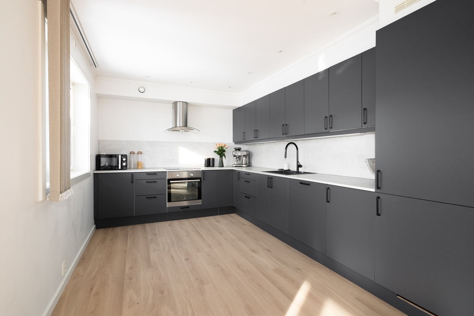 Delikat og moderne kjøkken i delvis åpen løsning. Innredningen har integrerte hvitevarer og godt med oppbevaringsplass. Galleribilde