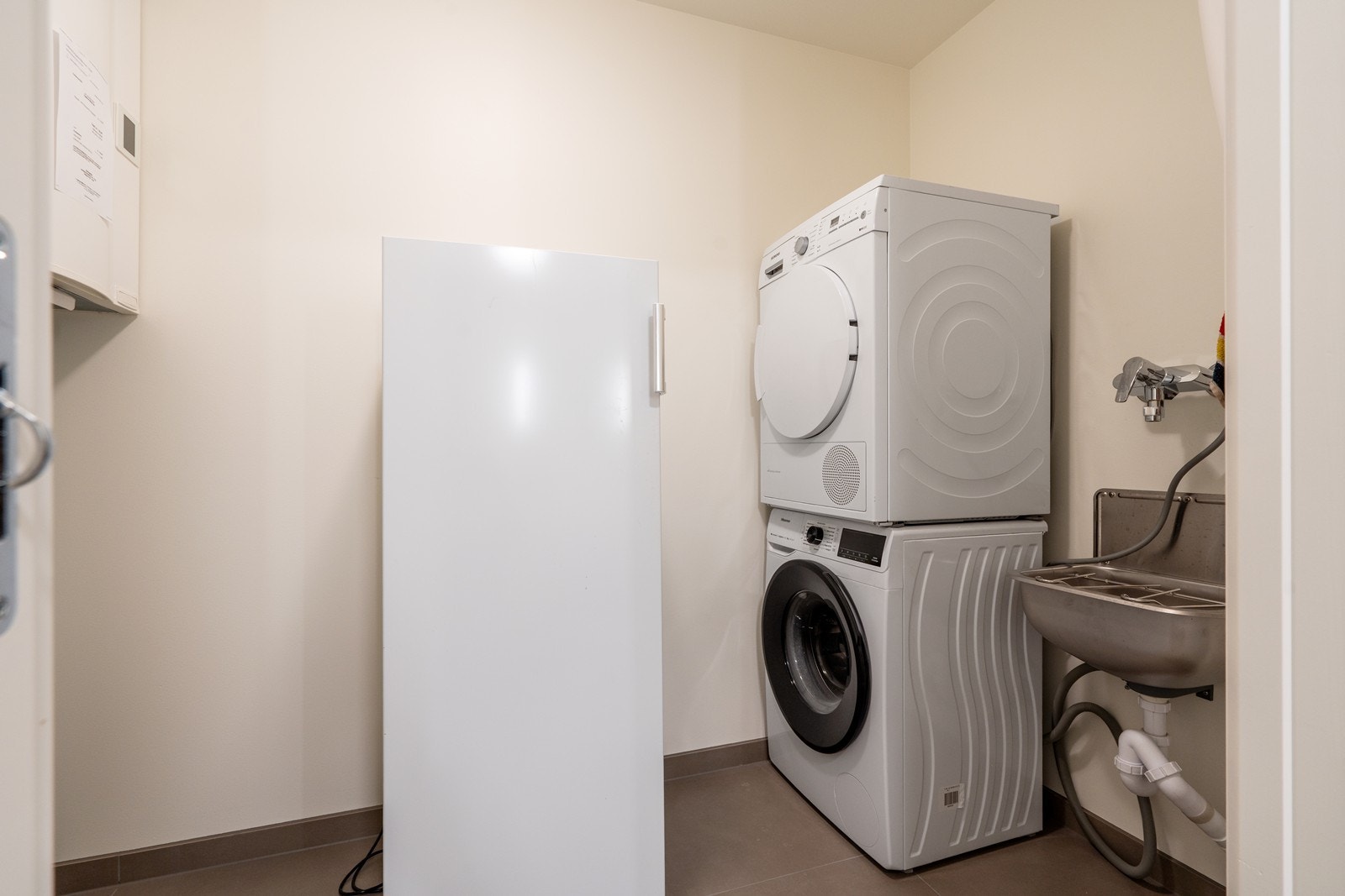 Vaskrerom/teknisk rom i forbindelse med bad med enkel utslagsvask. Skyvedørsløsning. Galleribilde