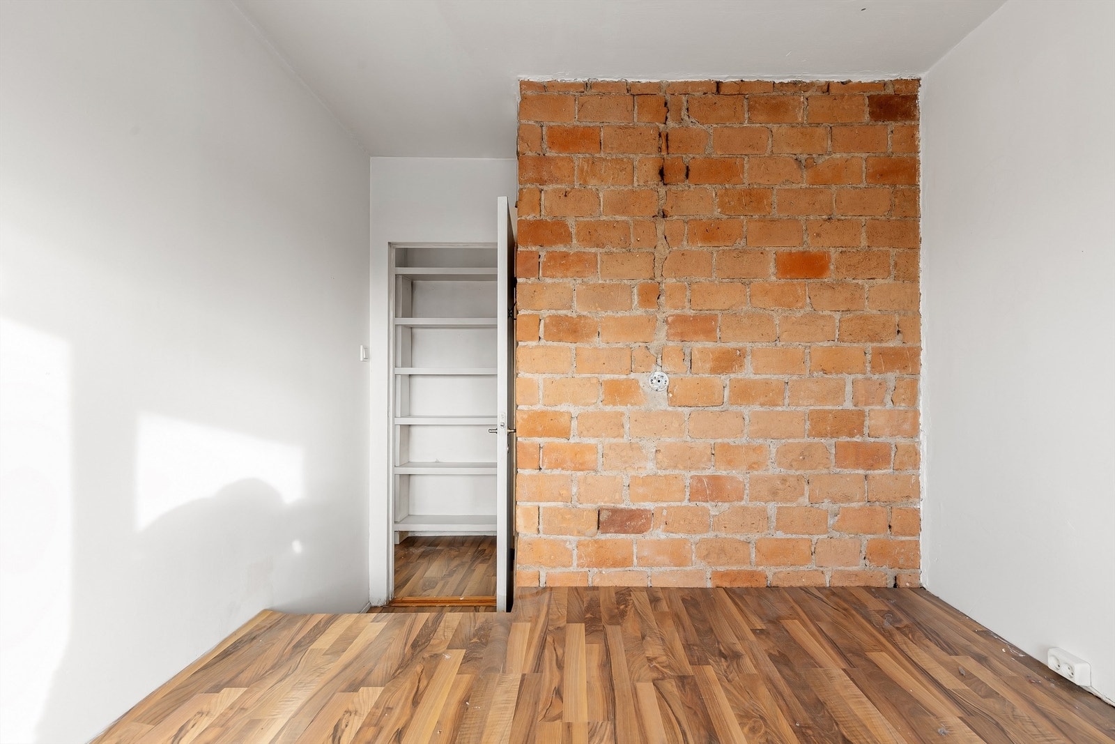 En eksponert teglsteinsvegg gir karakter til rommet, som også har en tilknyttet bod. Galleribilde