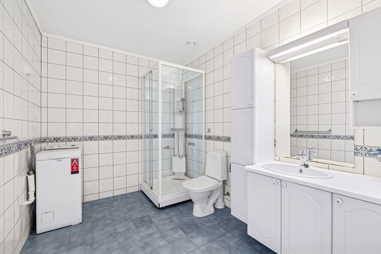 Romslig, flislagt bad med behagelig gulvvarme og opplegg for vaskemaskin. Galleribilde