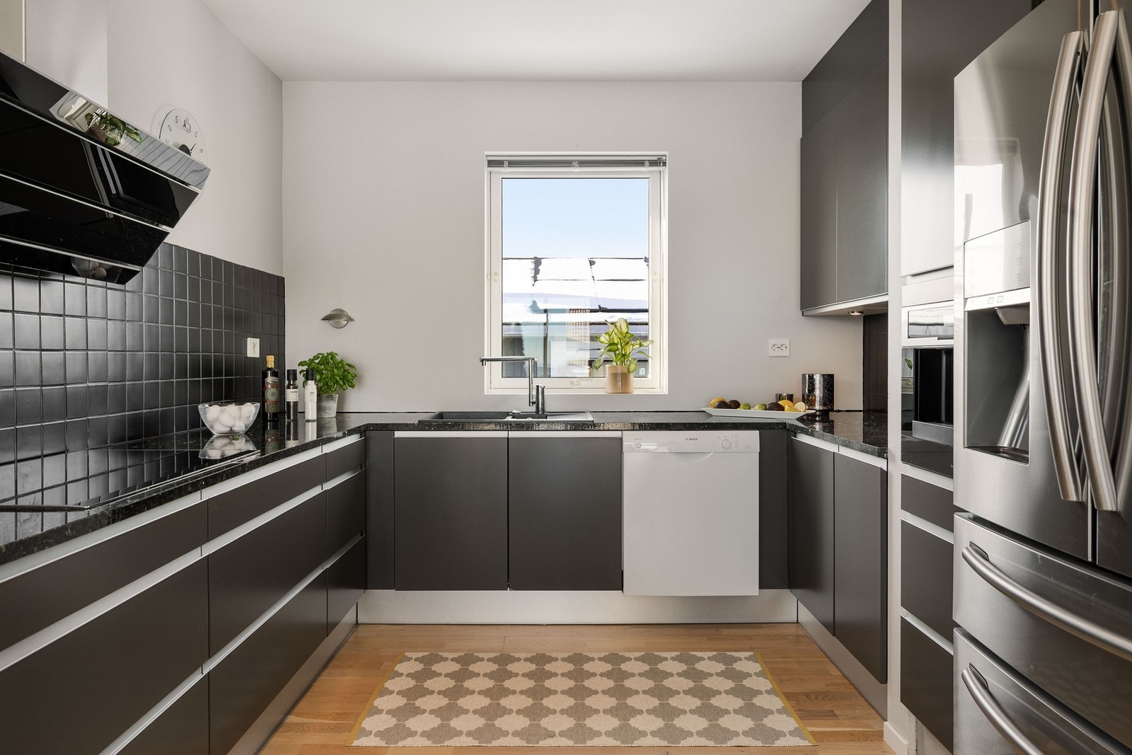 Stilrent kjøkken med fronter i moderne dempet fargevalg. Flott benkeplate i stein som gir gode arbeidsflater. Galleribilde