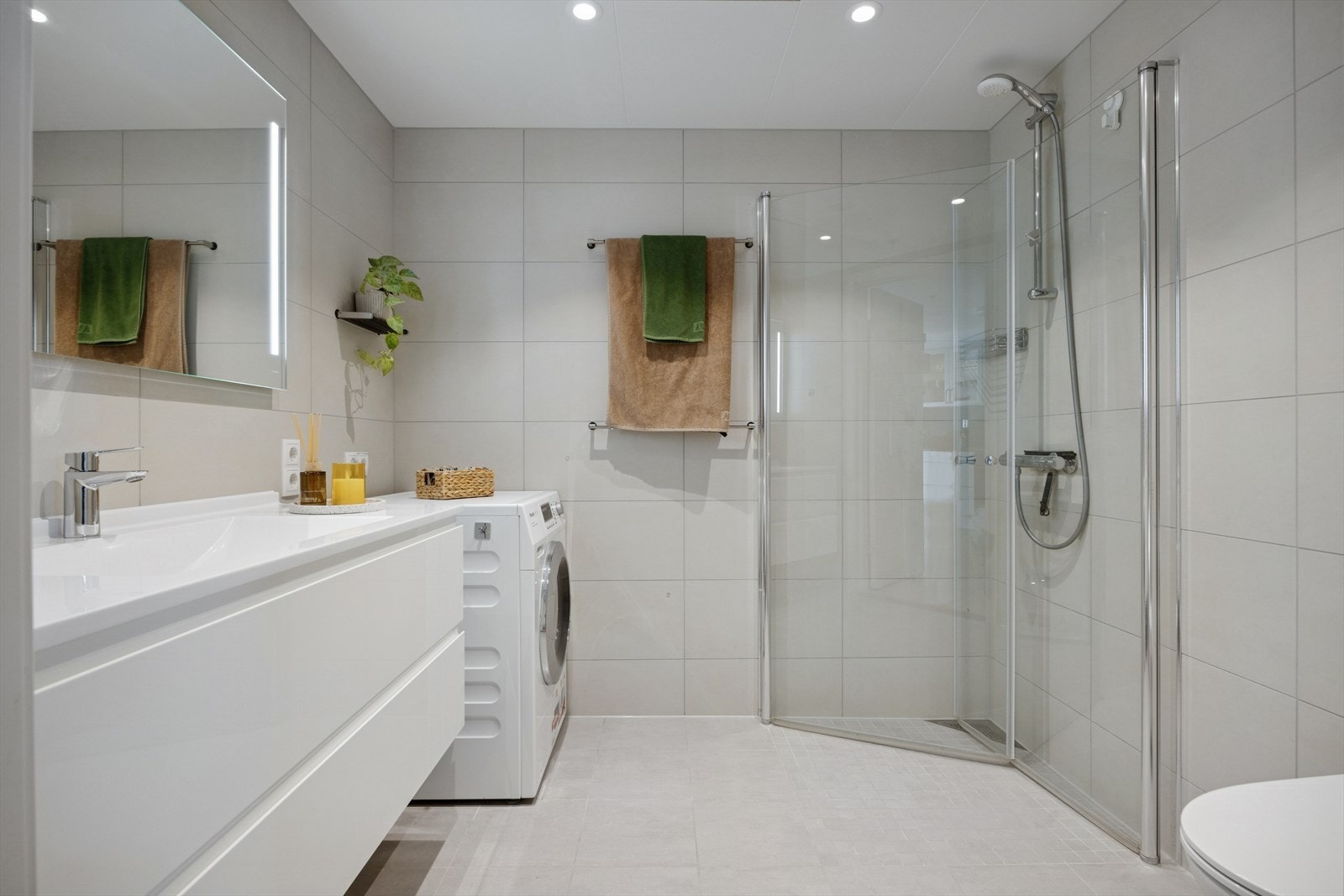 Badet er en prefabrikkert våtromskabin med flislagte overflater og opplegg for vaskemaskin. Galleribilde