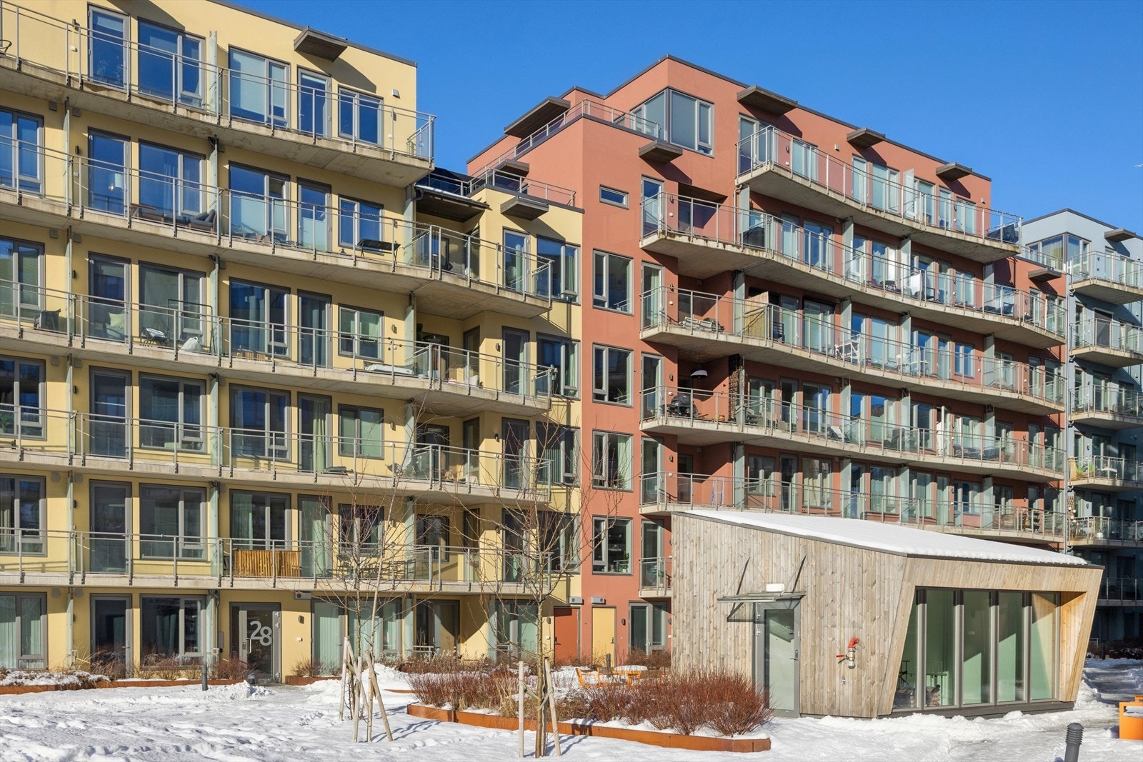 Bygget fra 2020 har en moderne fasade med pussede murflater og heisadkomst. Galleribilde