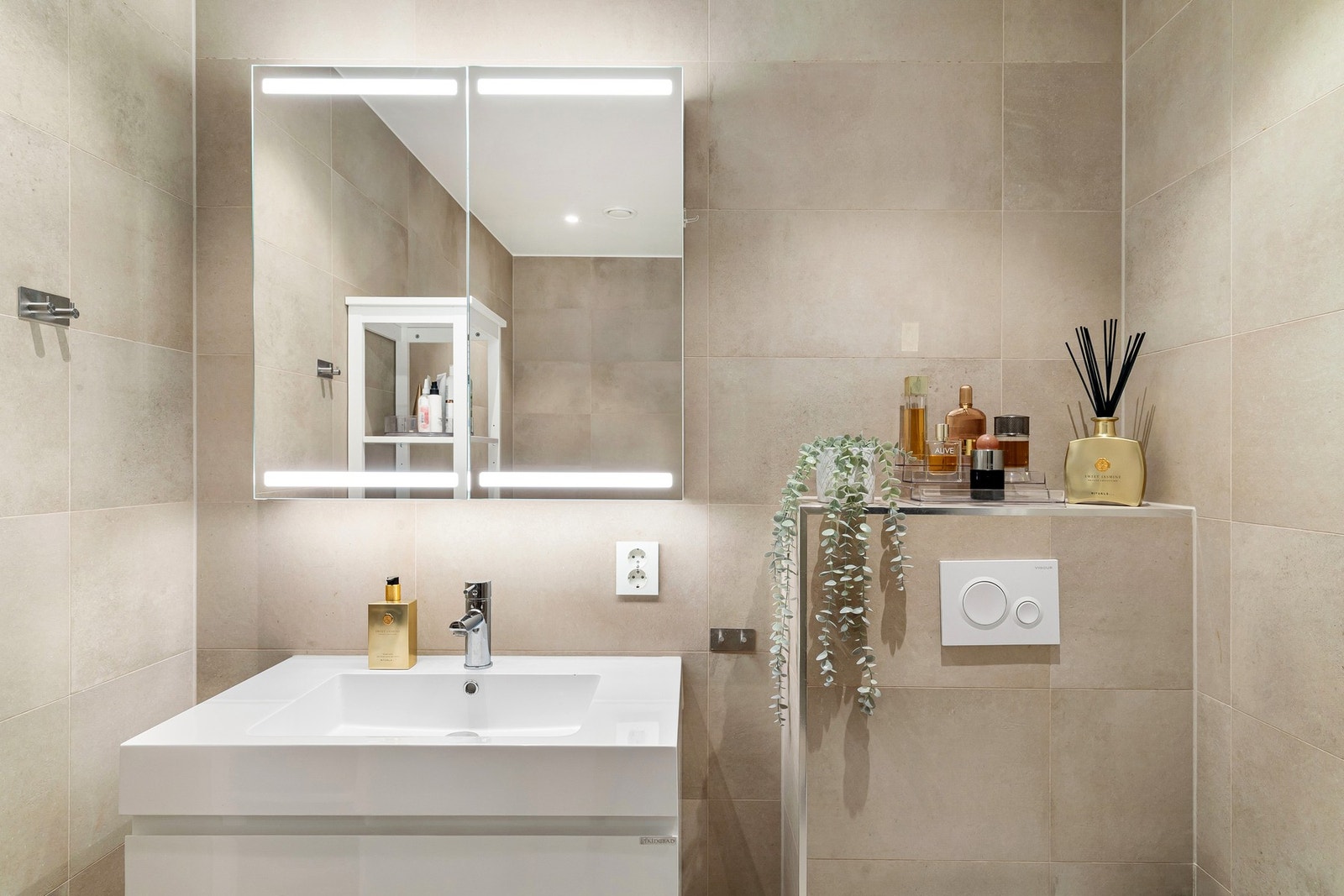 Badet er utstyrt med vegghengt servantinnredning med slette skuffefronter, heldekkende servant og vegghengt toalett. Galleribilde