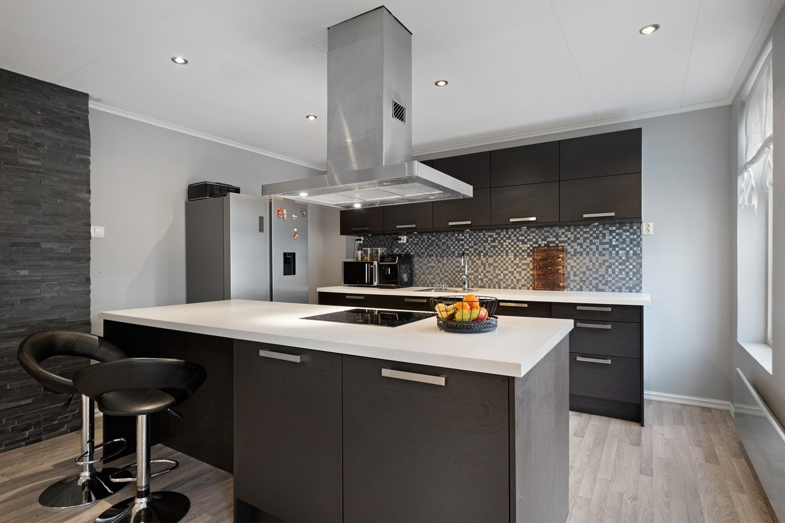 Kjøkken med kjøkkenøy - romslig innredning som har godt med oppbevaring og benkeplass Galleribilde