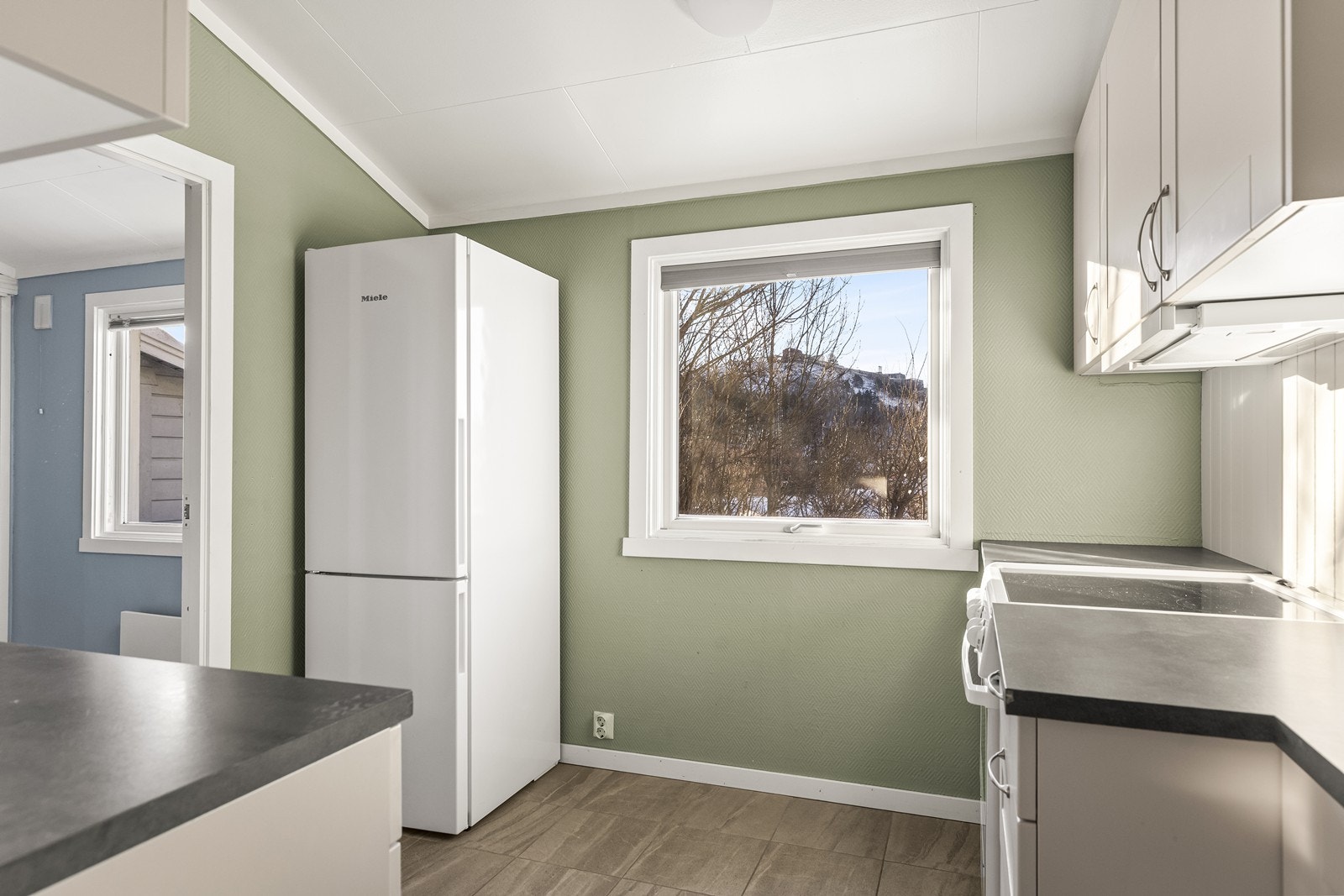 Kjøkkeninnredning fra Mesterkjøkken med flislagt gulv og elektrisk gulvvarme. Galleribilde