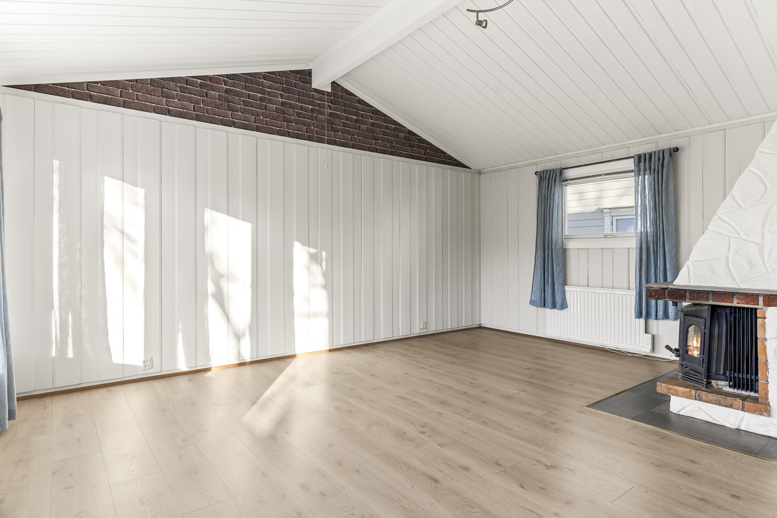 En peisovn i stuen sørger for effektiv oppvarming og en hyggelig atmosfære. Galleribilde