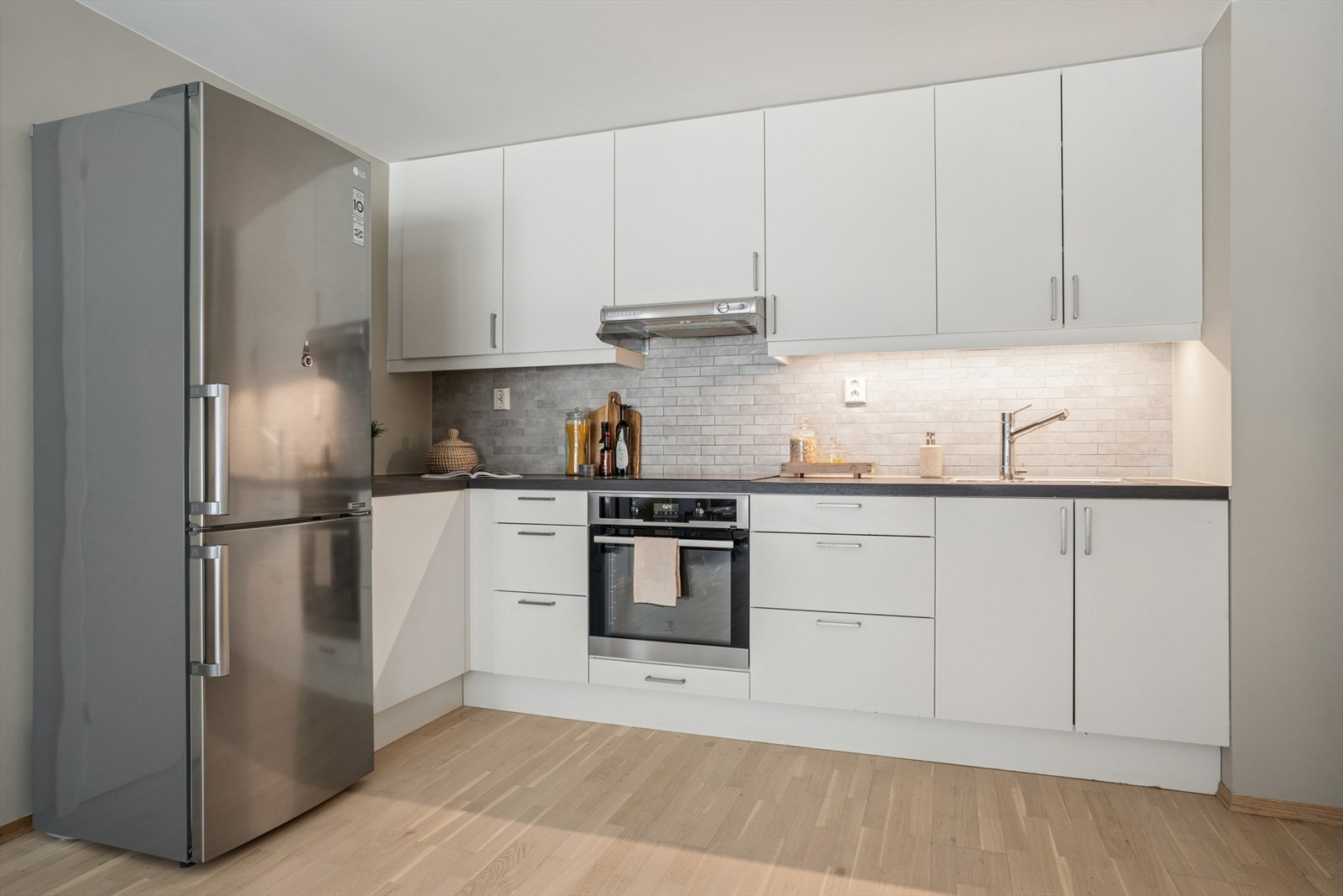 Lyst og praktisk kjøkken med god planløsning. Det byr på rikelig med både skap og benkeplass. Galleribilde