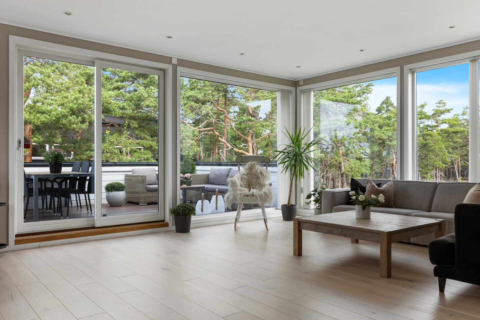 Store vinduer i oppholdsrom slipper inn lyset og naturen i boligen Galleribilde