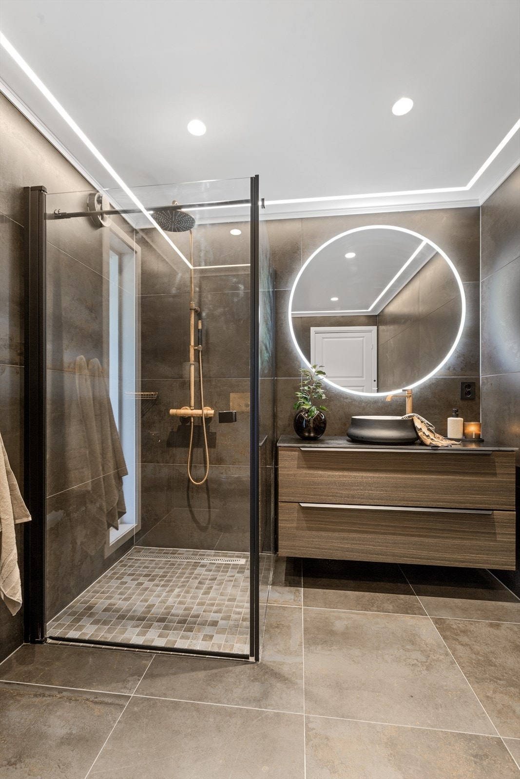 Badet har installert dusjhjørne - baderomsinnredning - spesil med integrert lys - toalett Galleribilde