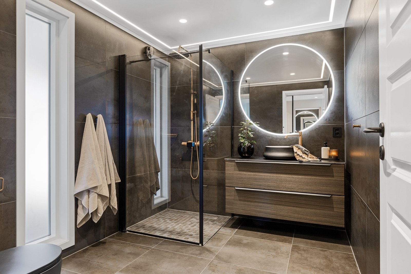 Særdeles flott flislagt bad med varmekabel. Fine detaljer som glir over hverandre med rustikk - kobber - ledstriper i himling - Vakkert! Galleribilde