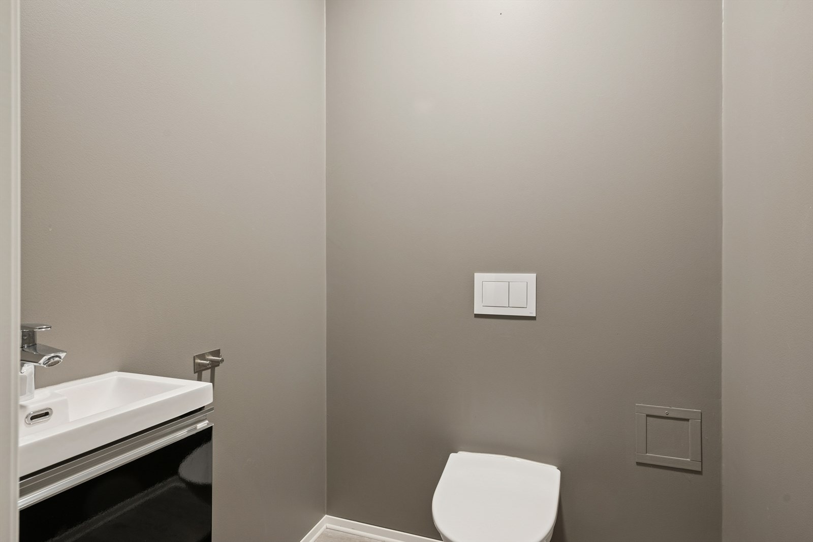 Praktisk gjestetoalett i første etasje med vegghengt toalett og servant. Galleribilde