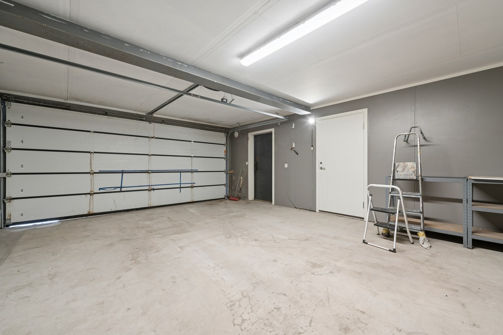 Integrert og romslig garasje med god takhøyde og betonggulv. Galleribilde