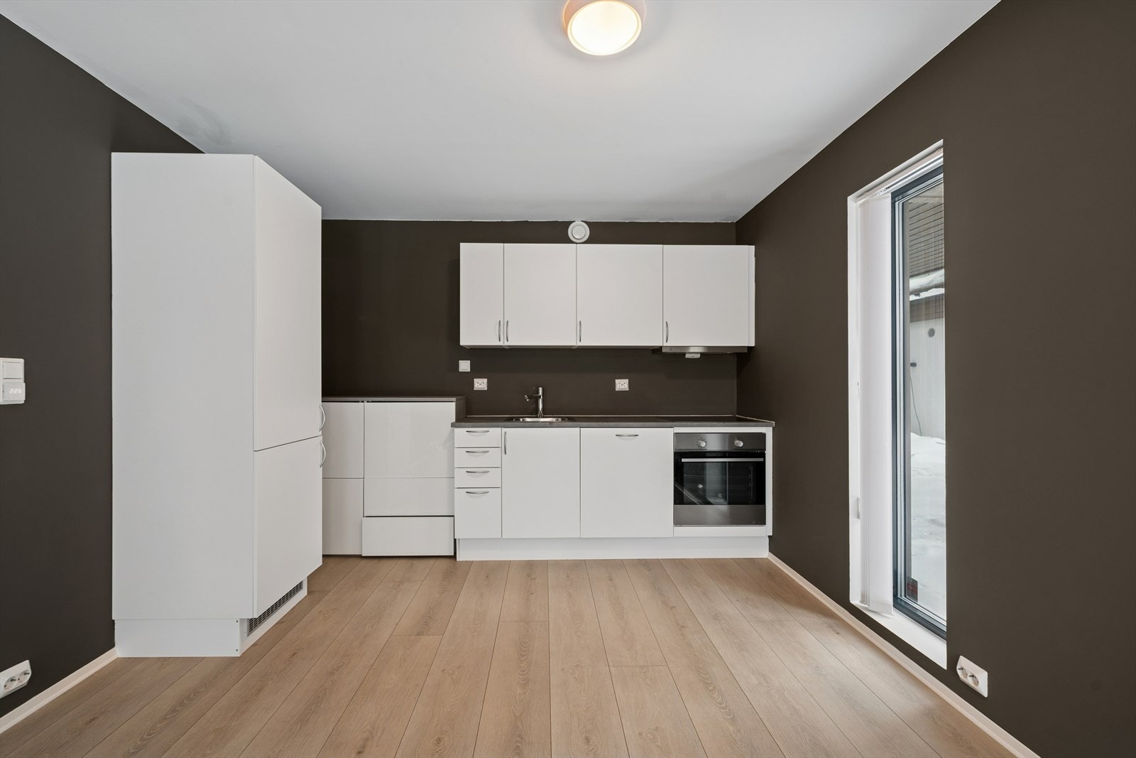 Kjøkkeninnredningen i hybelen har integrert stekeovn, koketopp og oppvaskmaskin. Etter at bildene ble tatt, er det montert en dør i venstre hjørne som knytter hoveddelen til hybelen. Galleribilde