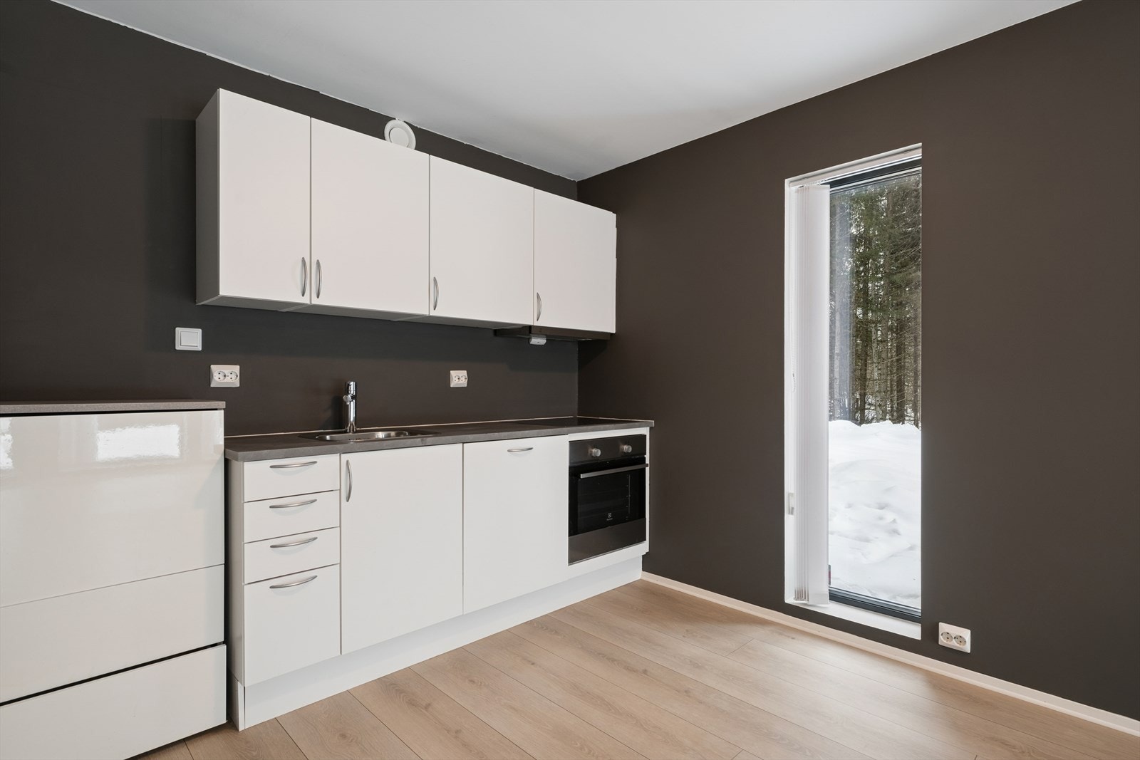 Praktisk kjøkken med laminatbenkeplate og ventilator med kullfilter. Galleribilde