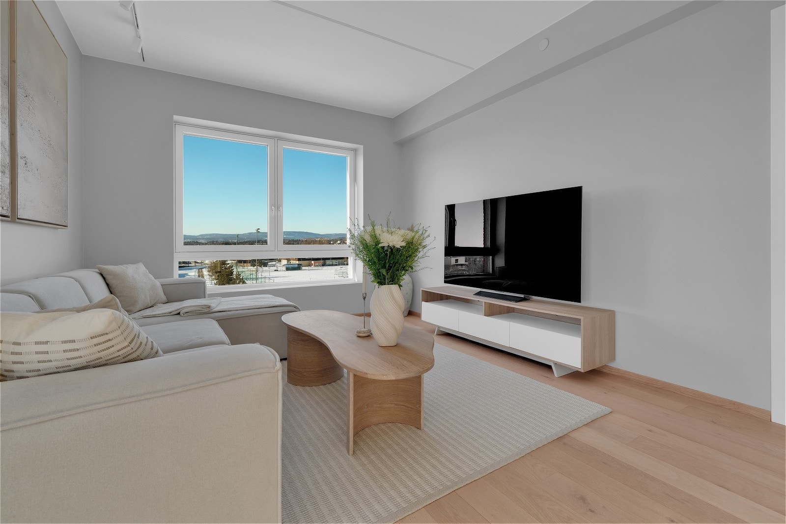 Romslig og lys stue med store vindusflater som gir godt med lysinnslipp som skaper en luftig og åpen romfølelse Galleribilde