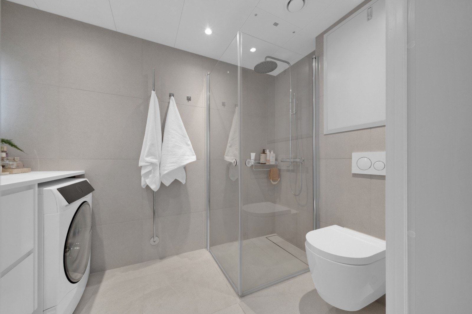 Delikat, flislagt bad med gulvvarme og innfelte downlights i himlingen Galleribilde