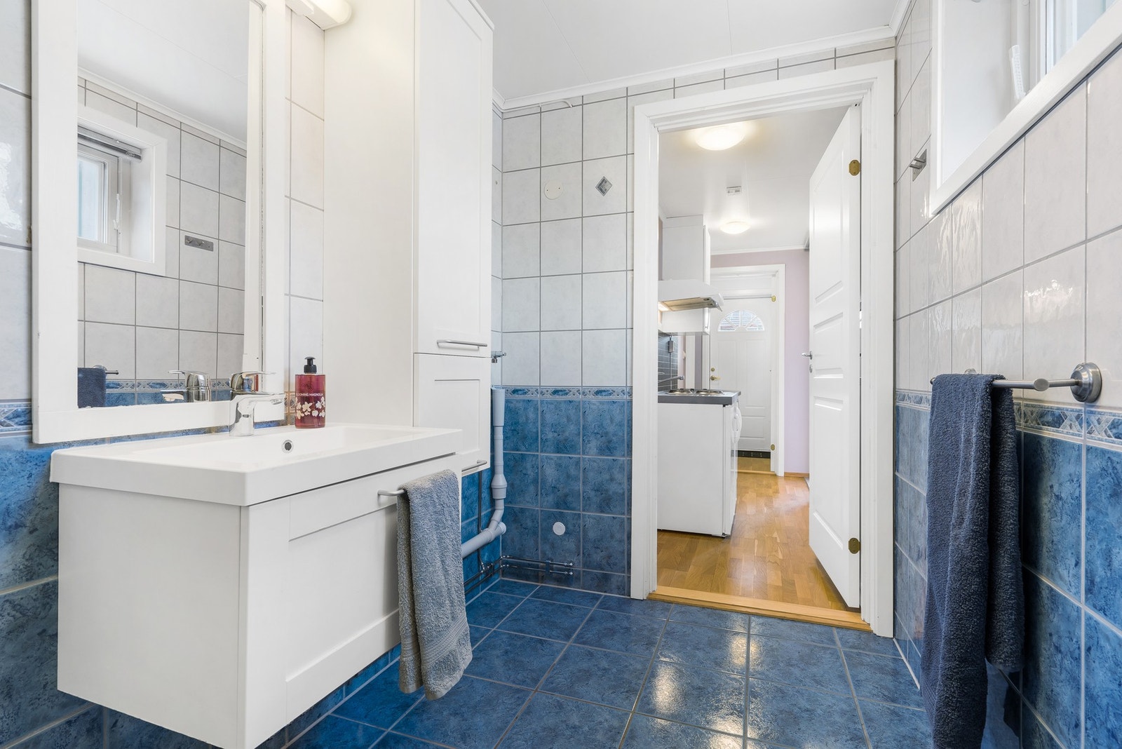 HYBEL - Romslig og flislagt bad med varme i gulv. Toalett, dusjkabinett og servantinnredning med speil og høyskap. Galleribilde