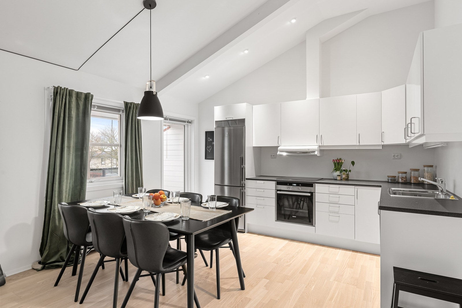 Kjøkkeninnredningen har glatte fronter og integrert stekeovn og platetopp. Galleribilde