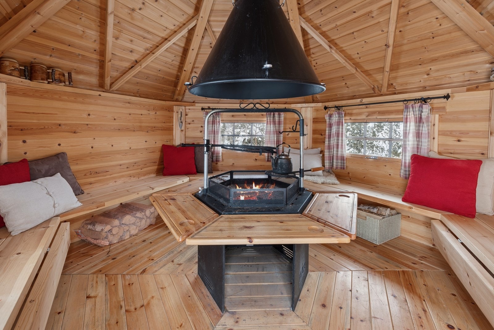 Inne i grillhytten er det benker og et sentralt ildsted for mat og varme. Galleribilde