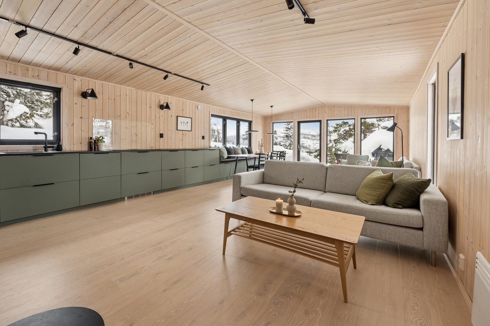 Den åpne løsningen mellom stue og kjøkken inviterer til sosialt samvær. Galleribilde