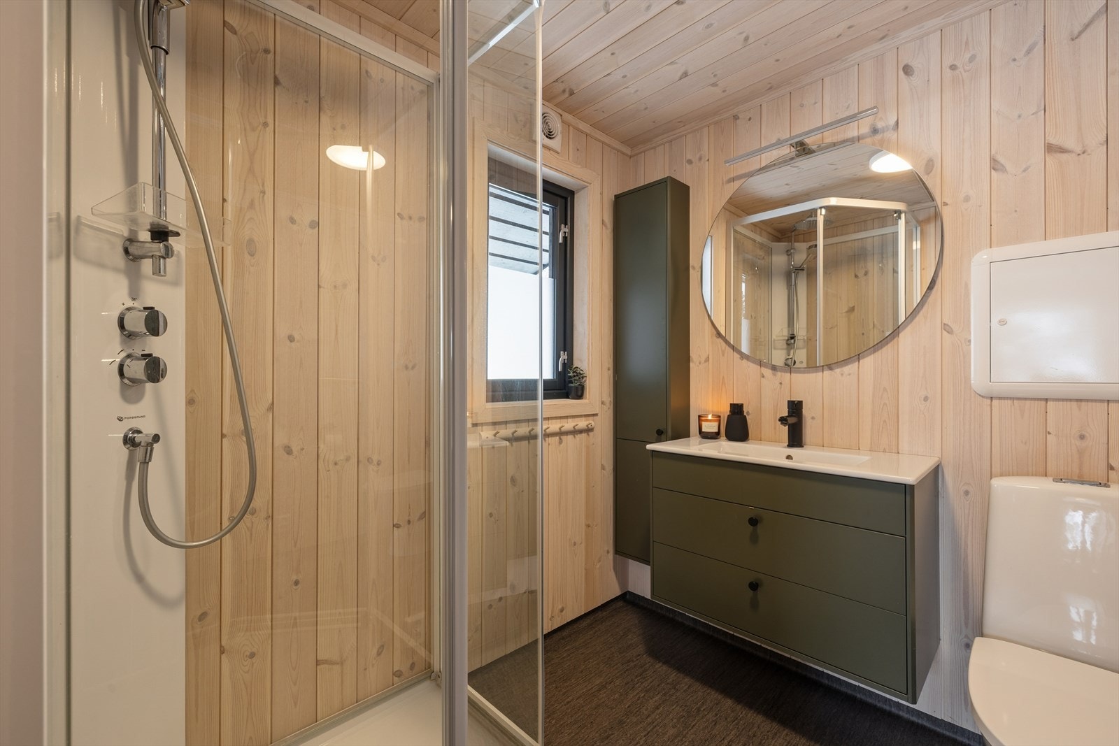 Bad med vinylbelegg på gulv og gulvvarme for økt komfort. Veggene har panel. Rommet er delikat innredet med baderomsinnredning, vegghengt toalett og dusjkabinett. Mekanisk avtrekk. Galleribilde