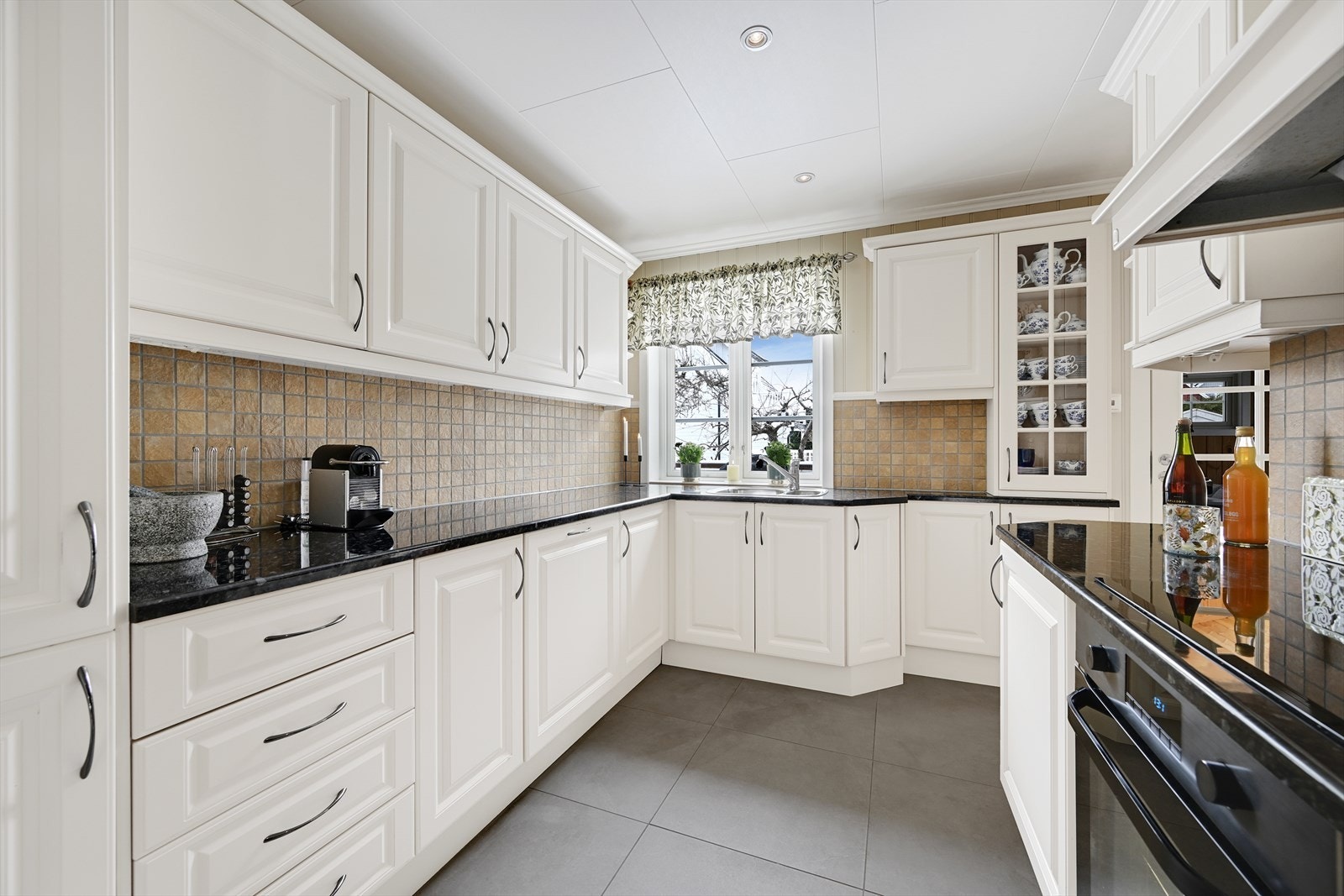 Kjøkken med induksjonstopp, stekeovn, kjøle- og fryseskap, oppvaskmaskin og komfyrvakt Galleribilde