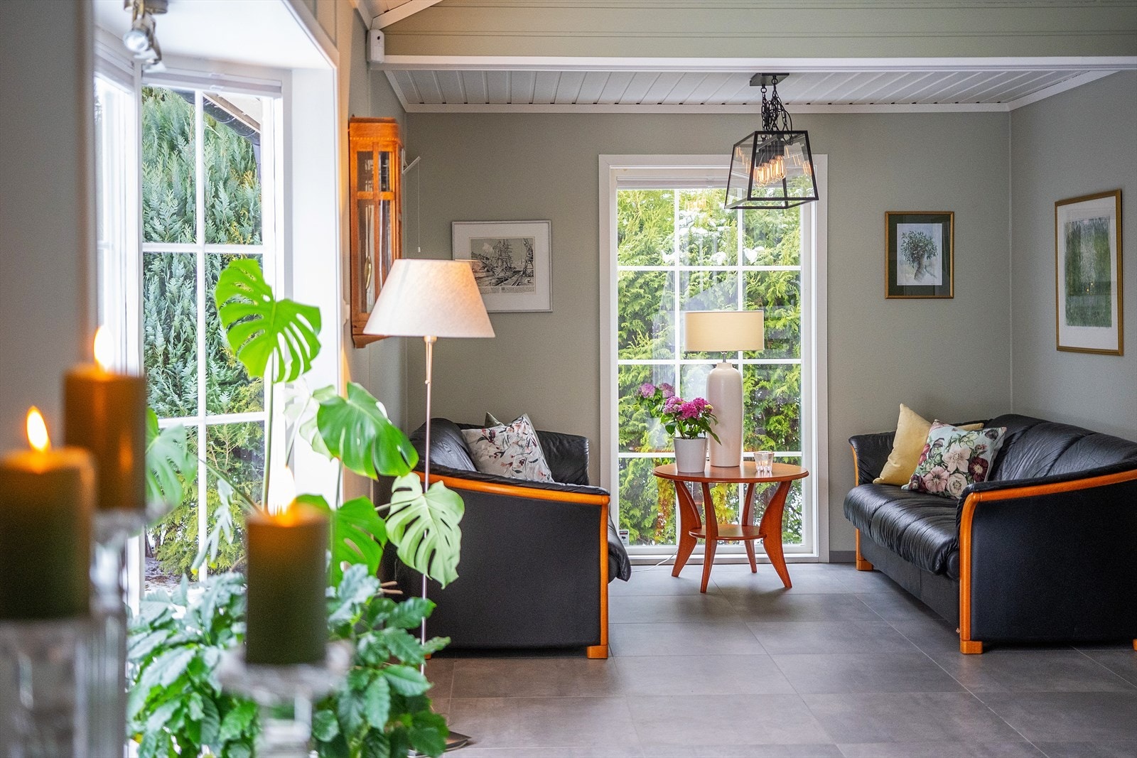 Stue i 1. etasje har en moderne stil med fliser på gulv, malte vegger og åpen løsning til 2. etasje. Galleribilde