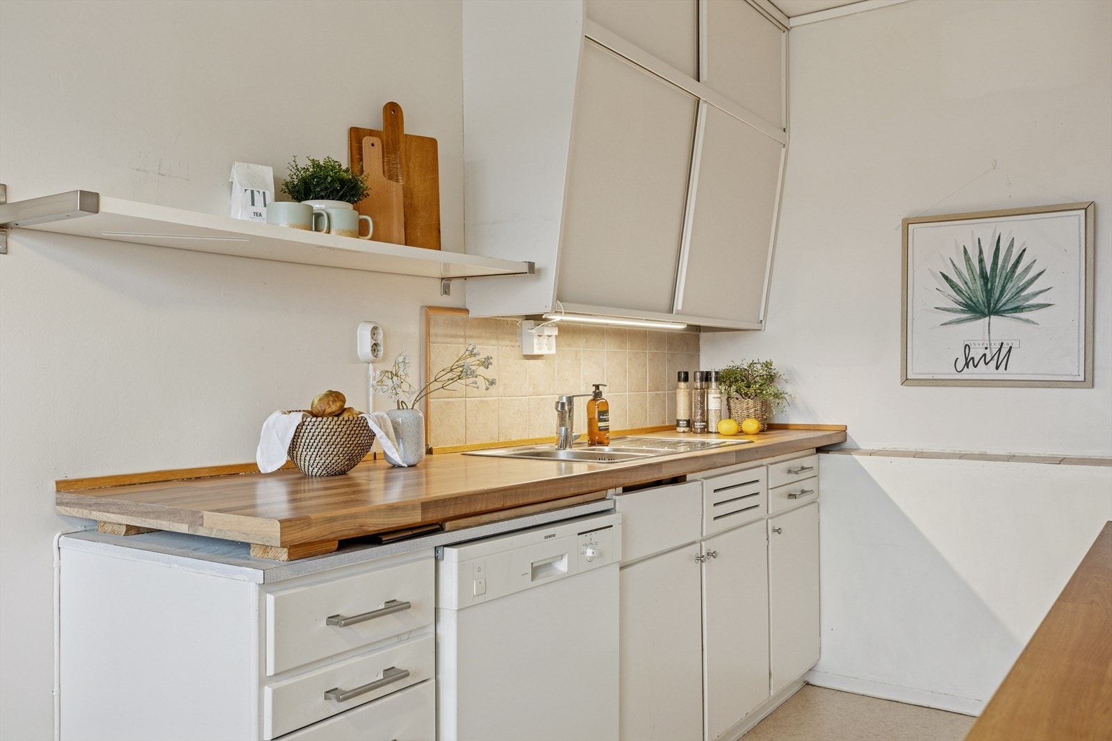 Kjøkkeninnredning med glatte fronter. Laminat benkeplater med nedfelt, stål vaskebeslag. Galleribilde