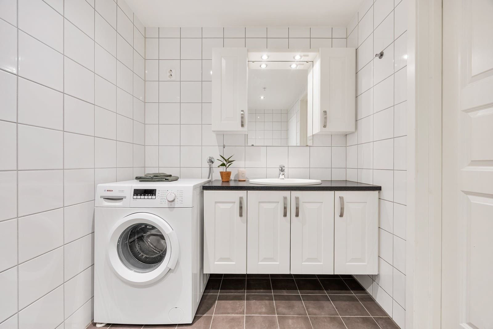 Badet har servantseksjon med skuffer og opplegg for vaskemaskin. Galleribilde