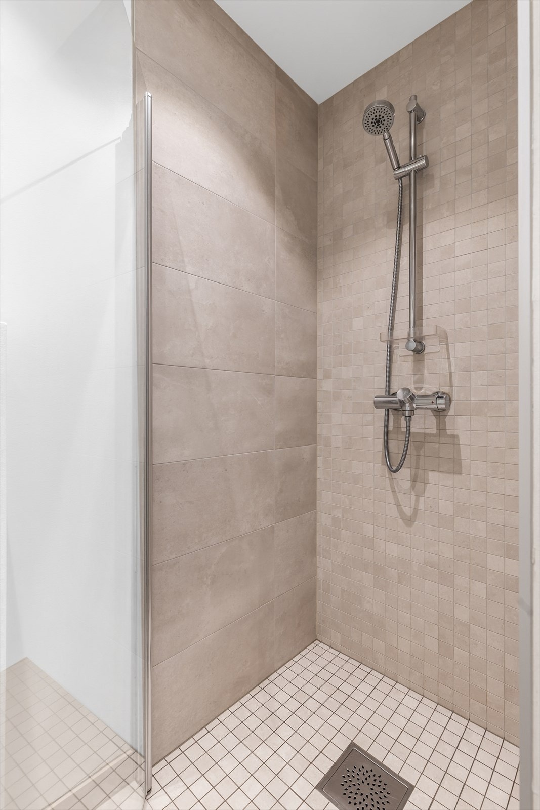 Dusjhjørne med dører. Vegghengt toalett. Mekanisk avtrekk med ventil i himling. Galleribilde