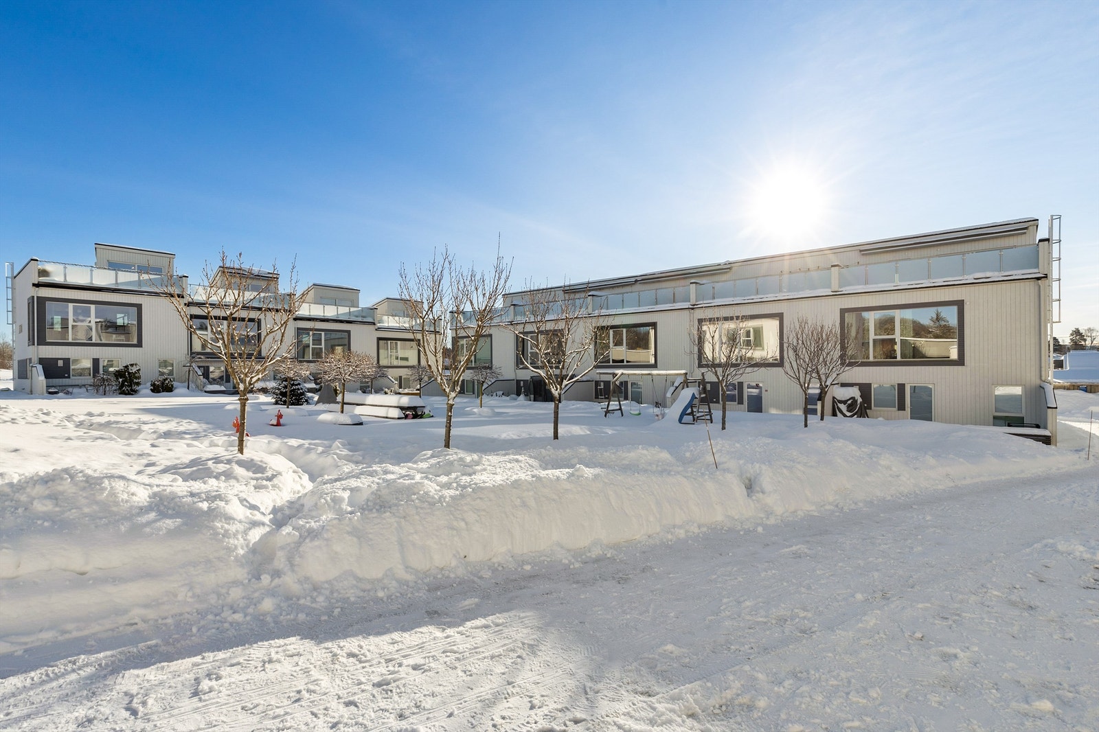 Felles tomteareal er opparbeidet med blant annet asfalterte veier, plenarealer og andre forskjellige beplantninger. Galleribilde