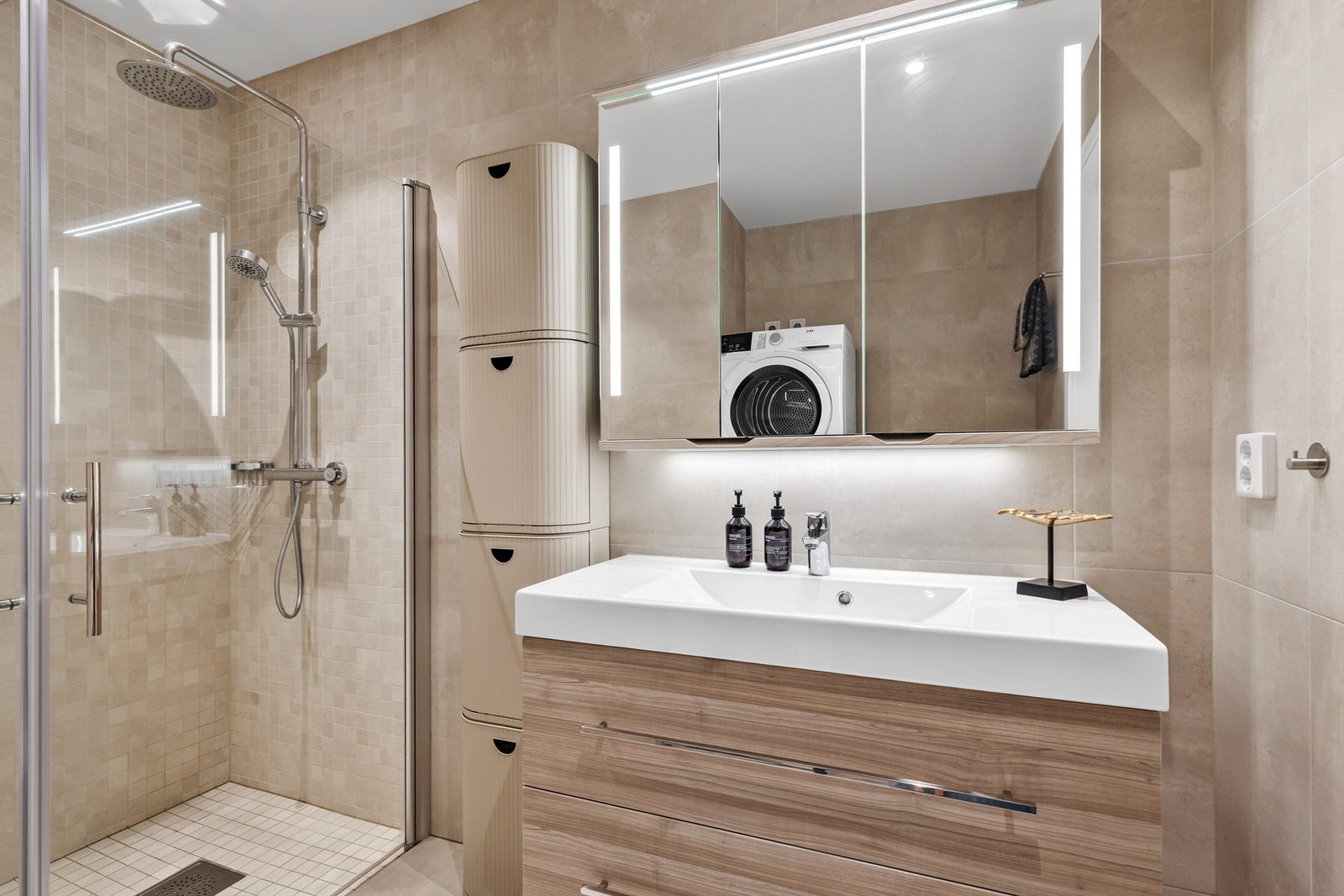 Speil med sidelys. Vegghengt baderomsmøbel. Dusjhjørne med dører. Vegghengt toalett. Mekanisk avtrekk med ventil i himling. Galleribilde