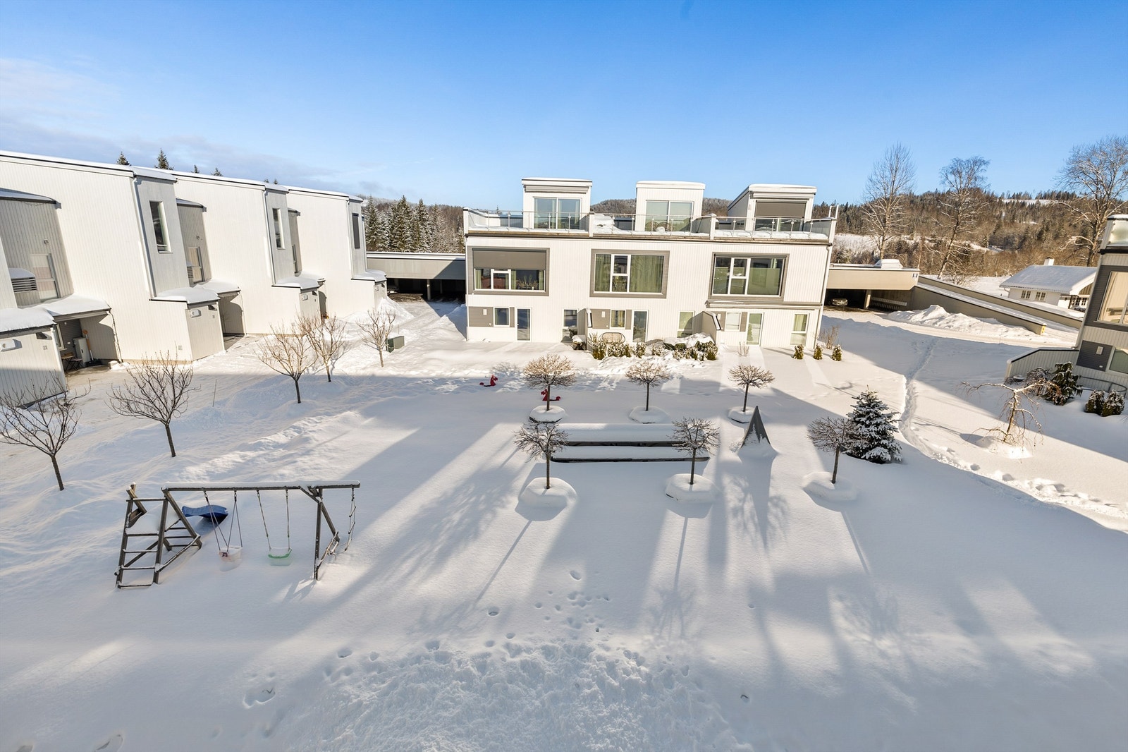 Felles tomteareal er opparbeidet med blant annet asfalterte veier, plenarealer og andre forskjellige beplantninger. Galleribilde
