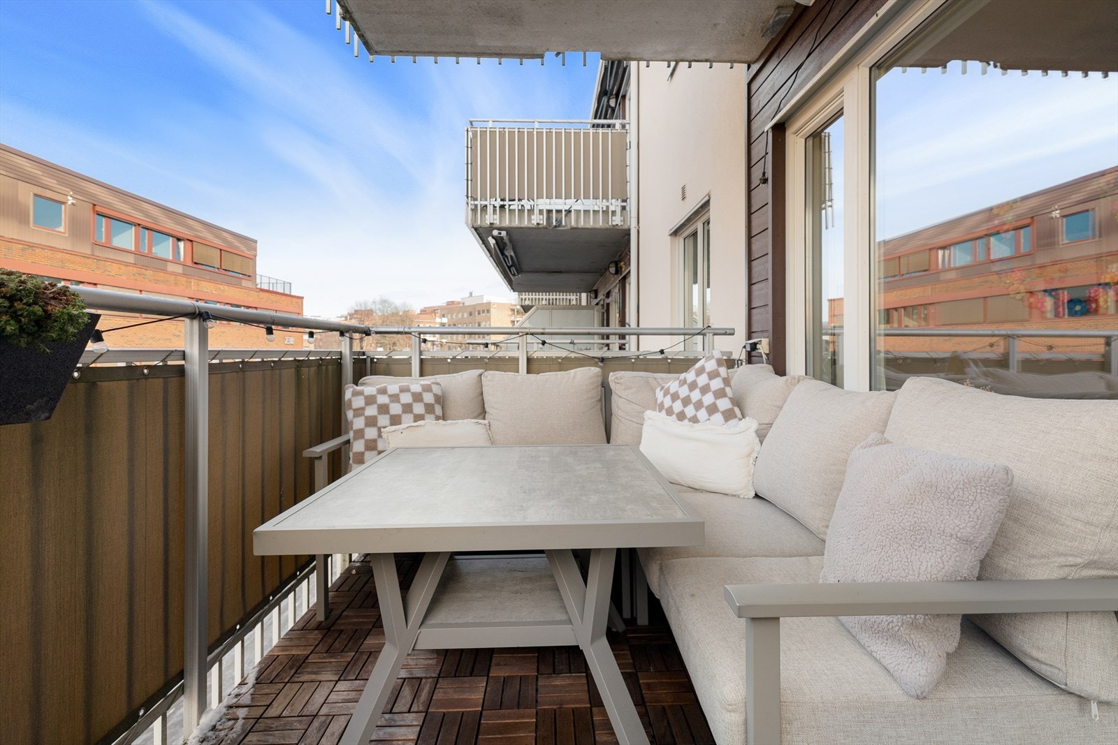 Balkongen har tre-fliser på gulvet og rekkverk i stål- og plateutførelse. Galleribilde