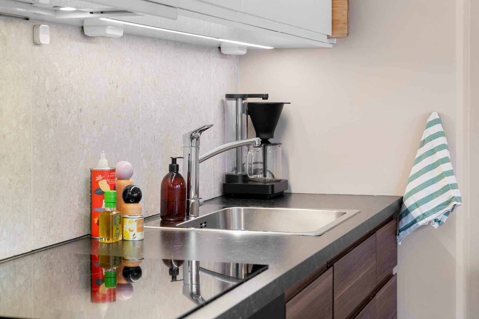 Benkeplaten har en nedfelt kum i rustfritt stål, og veggen over er praktisk flislagt. Galleribilde