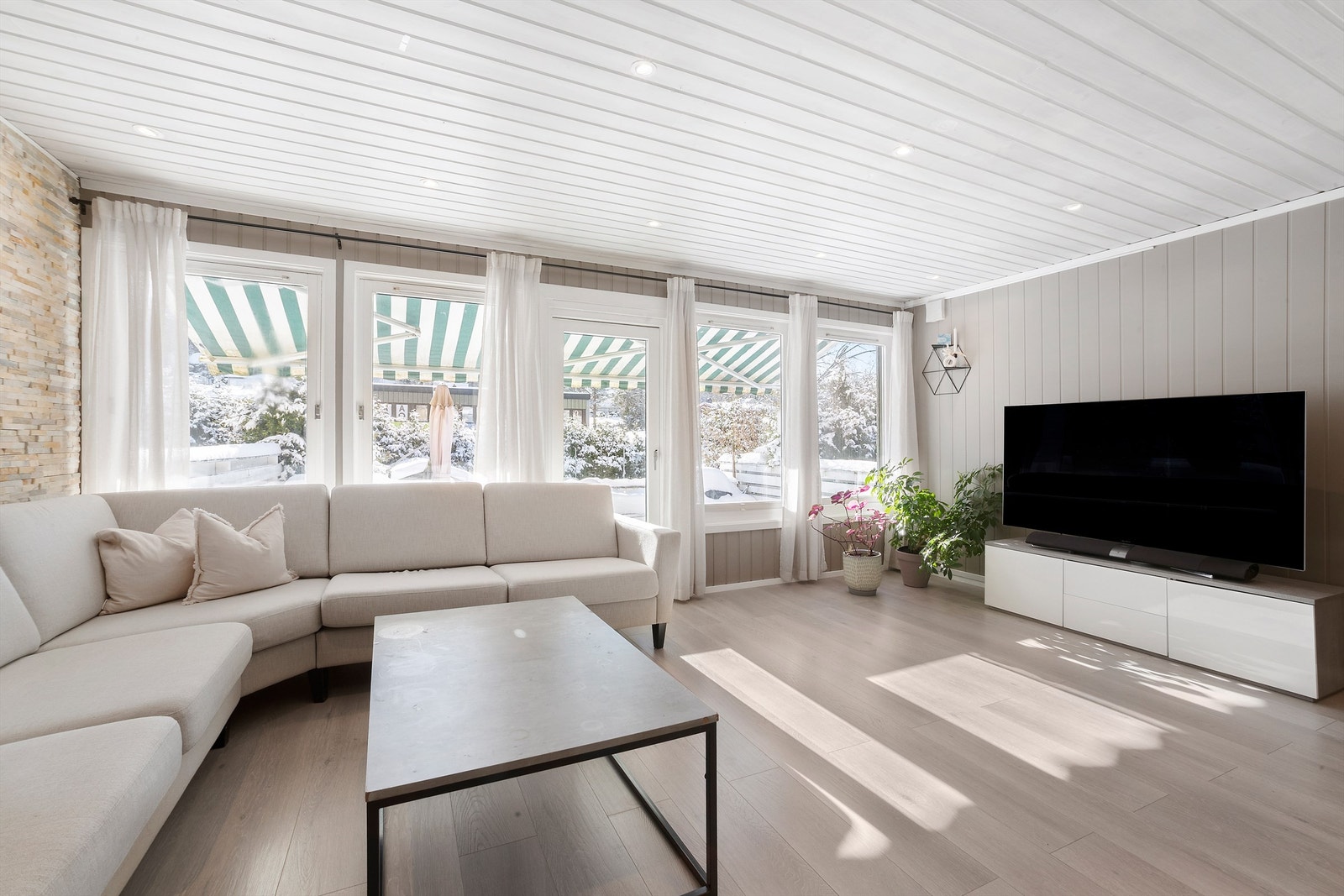 Stuen har en god størrelse med store vinduer som slipper inn rikelig med naturlig lys Galleribilde