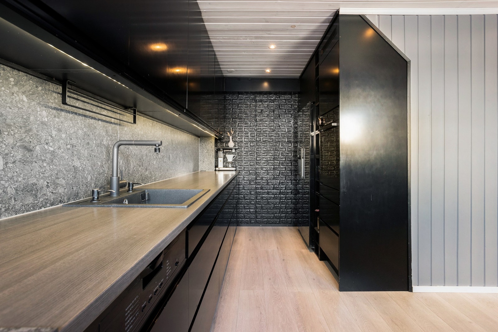 Moderne kjøkken fra 2020 med slette fronter og benkeplate i laminat samt bakvegg med terrazzostil Galleribilde