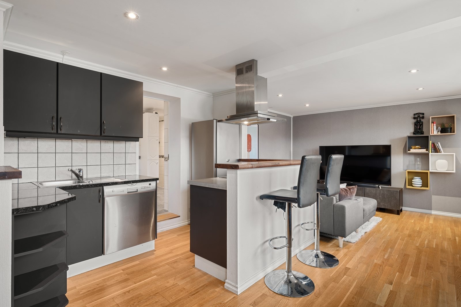 Leiligheten har en åpen stue- og kjøkkenløsning som skaper en sosial og luftig atmosfære. Galleribilde