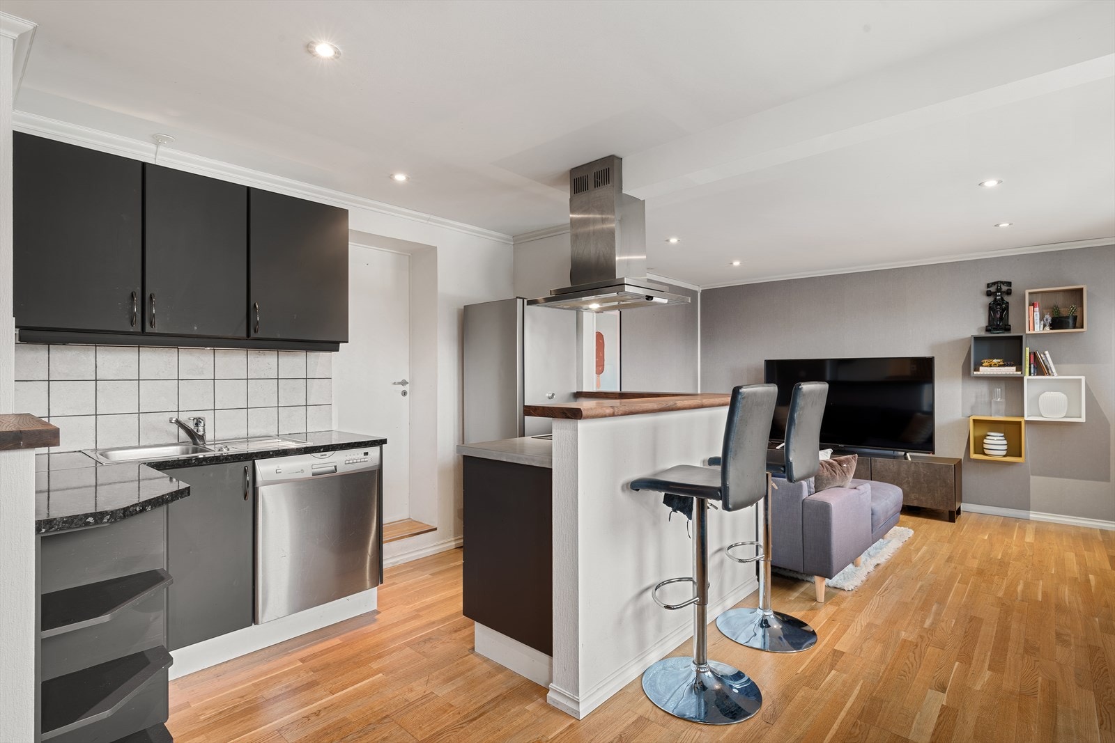 Kjøkkenet har innredning med glatte fronter, benkeplate av laminat og hvitevarer av Zanussi. Galleribilde