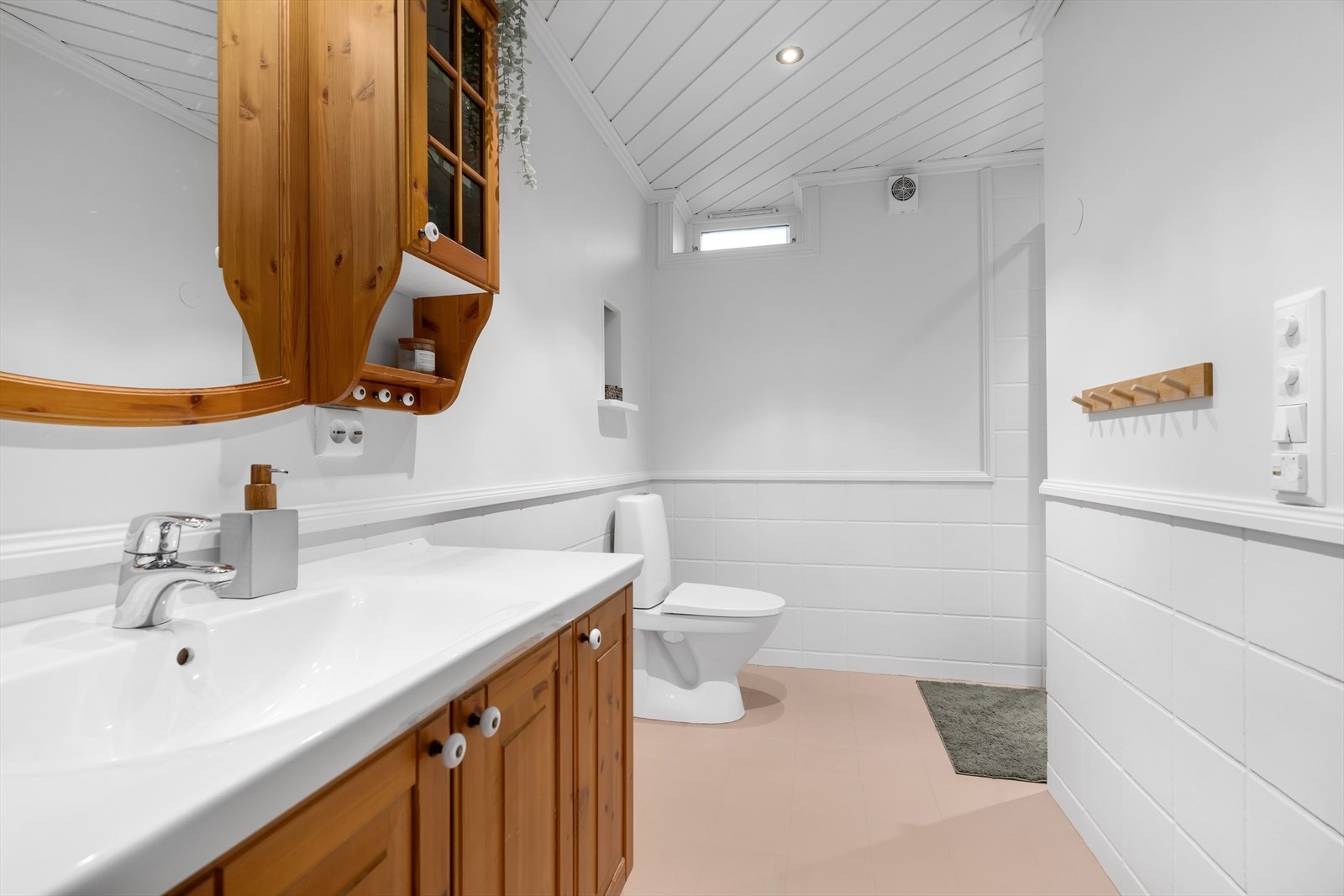 Badet har malte fliser og tapetserte overflater, med malte fliser også på gulvet. Galleribilde