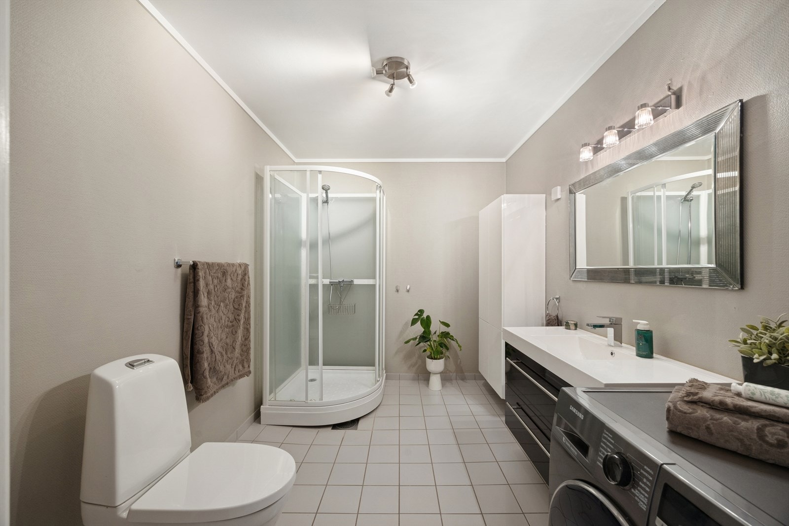 Innredningen består av sorte, glatte fronter, speil med belysning, romslig skuffeseksjon samt et ekstra høyskap som gir svært god oppbevaringsplass Galleribilde