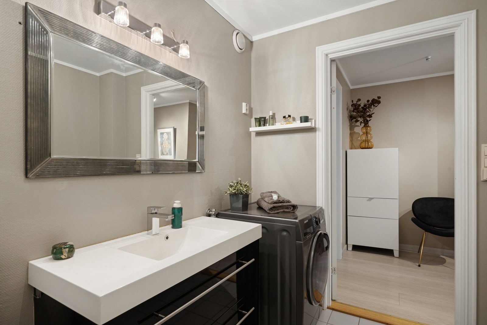 Badet har adkomst fra gangen og oppleves som romslig. Det fremstår lyst, delikat og innbydende, med moderne løsninger og praktisk innredning Galleribilde