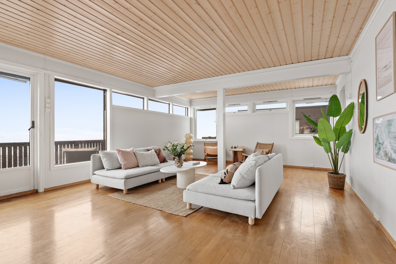 Lys og luftig stue med parkett på gulv, malte plater på vegger og panel med downlights i himling Galleribilde