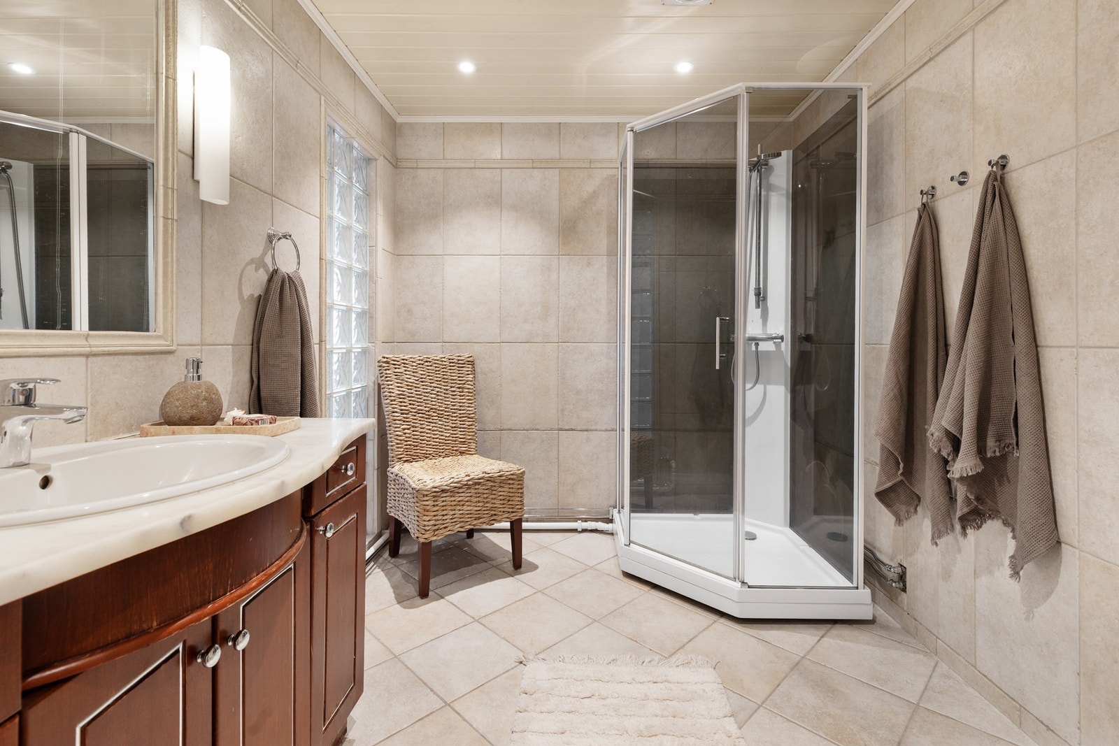 Helfliset bad med elektriske varmekabler i gulv og malt trepanel med downlights i himling Galleribilde