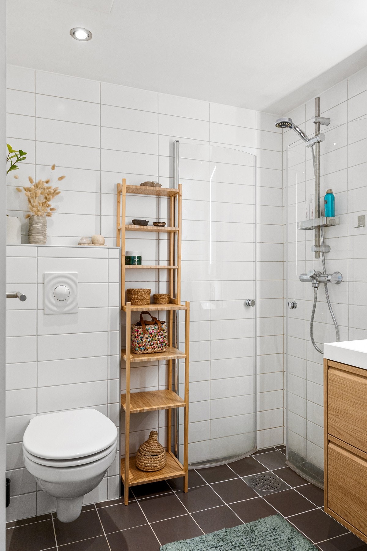 Badet er innredet med servantskap med nedfelt servant, veggskap med speildører og belysning, vegghengt toalett og dusjsone. Galleribilde